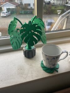 Mit print jeg har vedhæftet er en plante hvor bladene fungere som bordskånere. Jeg har også vedhæftet et af mine allerførste print hvor jeg har lavet en kaffefilterholder ud af nogle træ hyldeknægte. Begge prints har jeg selv designet.