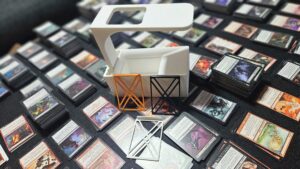 Adskillere/opdelere til MTG kort, så det er nemmere at holde dem adskilt i kasser. Samt en kasse med holder til at scanne kortene, hvor en telefon ligger på holderen/armen og kameraet peger ned i selve kassen, hvor kortene lander ovenpå hinanden, ved at glide ned af en sliske.
