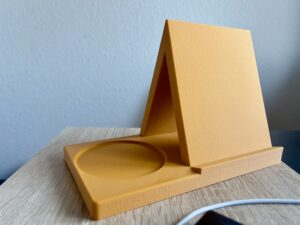 En multifunktionel A‑formet holder designet fra bunden som et lille hverdagsværktøj. Ideen opstod ud fra behovet for en stabil stander, der både kan holde en bog eller tablet og samtidig fungere som en lille organiser. Derfor har designet en integreret rund fordybning, som giver plads til en kop, et lys eller småting. Printet i et stykke for maksimal styrke og et rent, minimalistisk udtryk. Et simpelt, men gennemtænkt 3D‑print, der gør hverdagen lidt mere praktisk.