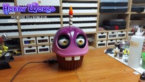 3D printet animatronic af Cupcake fra Five Nights at Freddy's. Kan styres med en lille fjernbetjening og er drevet af et lithium batteri. Modellen er printet i PLA på en Creality Hi.