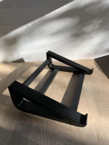Dette projekt er et funktionelt 3D-printet stativ designet til at løfte en PC fra bordet og give bedre luftcirkulation samt en mere organiseret arbejdsplads. Stativet hæver computeren i en stabil vinkel, hvilket både kan forbedre køling og gøre det nemmere at arbejde ved skrivebordet. Konstruktionen består af elleve 3D-printede dele: to sidesektioner, tre tværstivere og skes skruer, som holder hele stativet sammen. Alle dele er printet og samles nemt med en unbrakonøgle, hvilket gør designet enkelt at montere og adskille igen. Designet viser, hvordan 3D-print kan bruges til at skabe robuste og praktiske løsninger til hverdagen. Ved at printe alle komponenter selv kan stativet nemt tilpasses forskellige computere og behov.